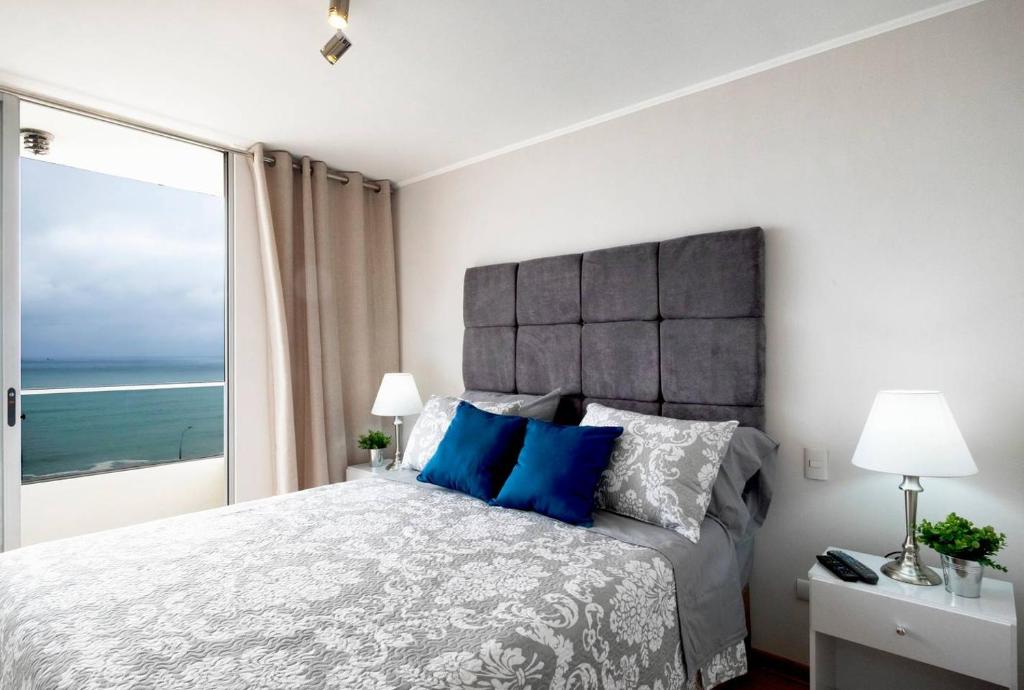 1 dormitorio con 1 cama grande y vistas al océano en Ocean View Close to Airport, en Lima