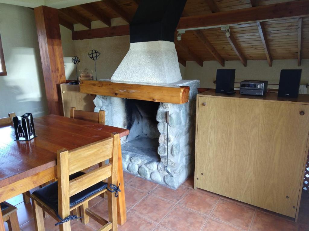 a living room with a fireplace with a wooden table and a table sidx sidx sidx at Enjoy Catedral in San Carlos de Bariloche