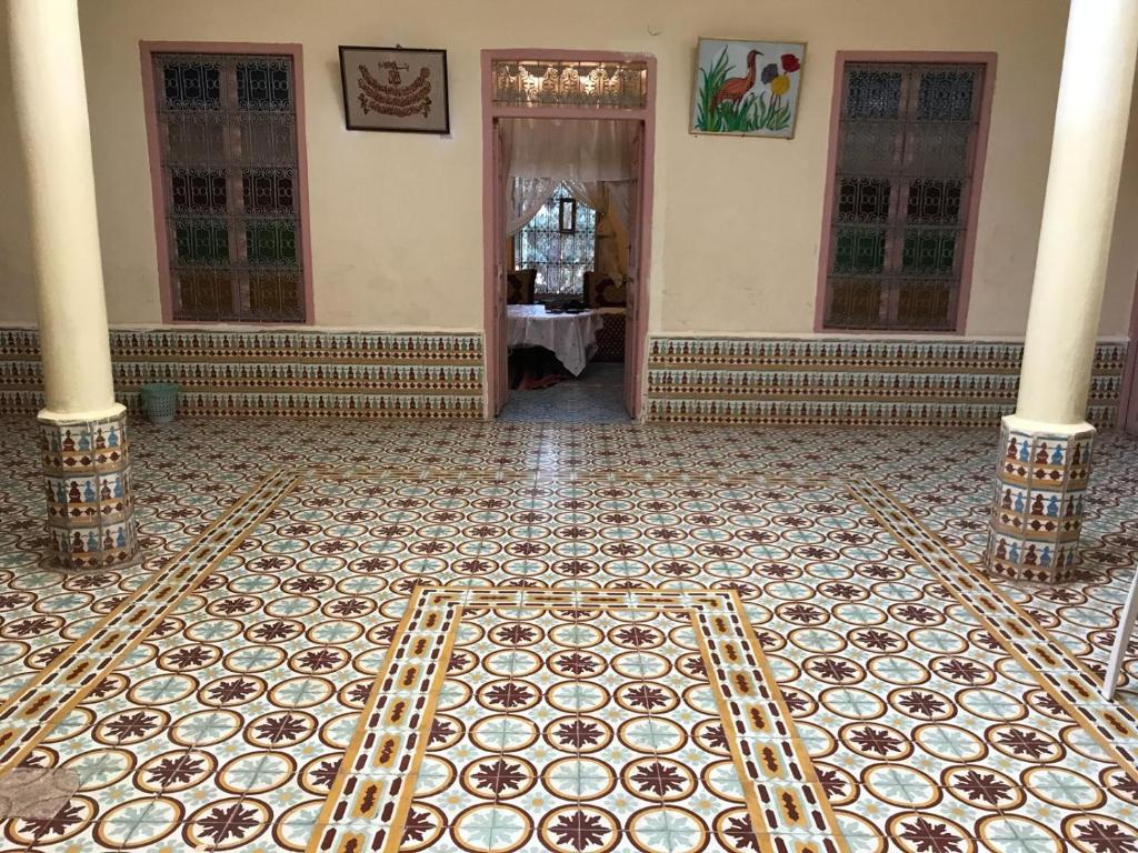 an empty room with a tiled floor and columns at Écologie oasis tafilalt CHEZ L' HABITANT in Er Rachidia