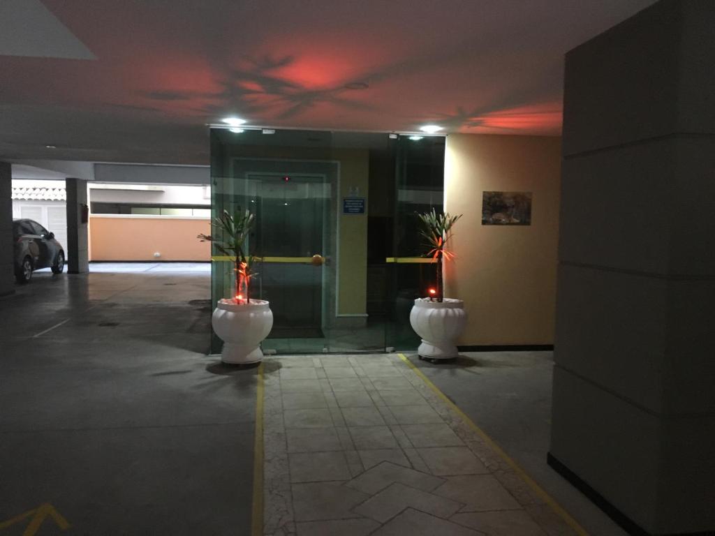 a lobby with two white vases with plants in it at Apartamento à 2 minutos da Praia, na Prainha em Arraial do Cabo in Arraial do Cabo