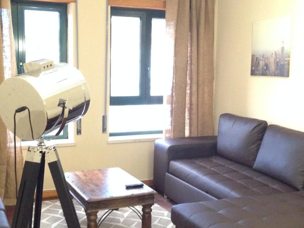 a living room with a hair dryer in front of a couch at Miguel Torga Gold in Coimbra