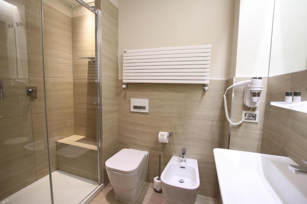 a bathroom with a shower and a toilet and a sink at Hotel Villa Margherita in Quercianella