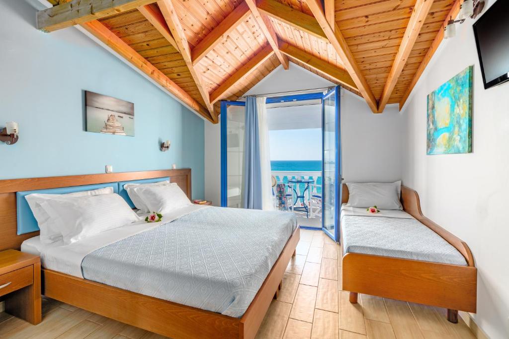 a bedroom with two beds and a view of the ocean at Mesogeios 2000 in Ligia