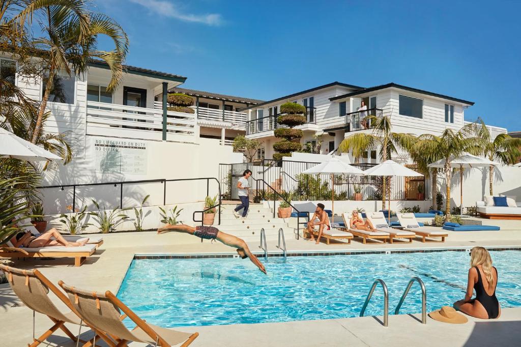 a person jumping into a swimming pool at a resort at Hotel Joaquin in Laguna Beach