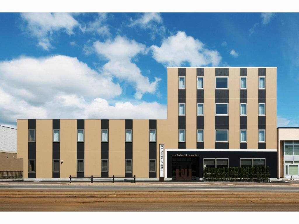 a large building with a bench in front of it at Credo Hotel Hakodate in Hakodate