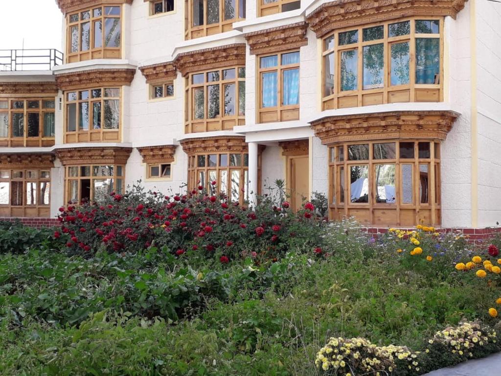 um edifício com janelas e flores em frente em Zee Guest House em Leh