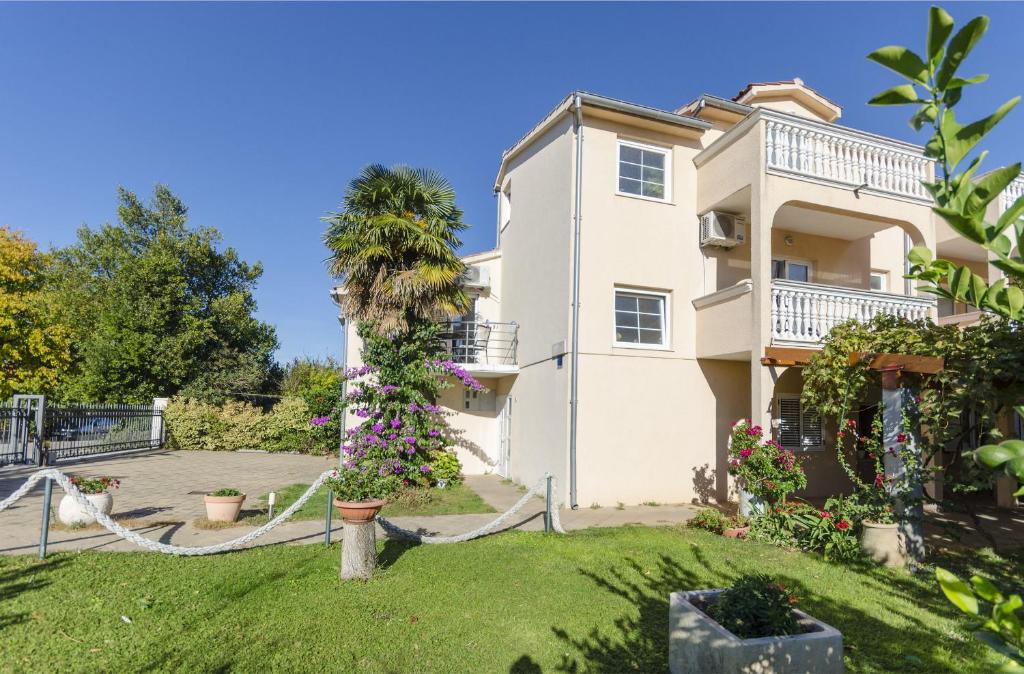 a house with a palm tree in front of it at Apartments Sweet garden in Vodice