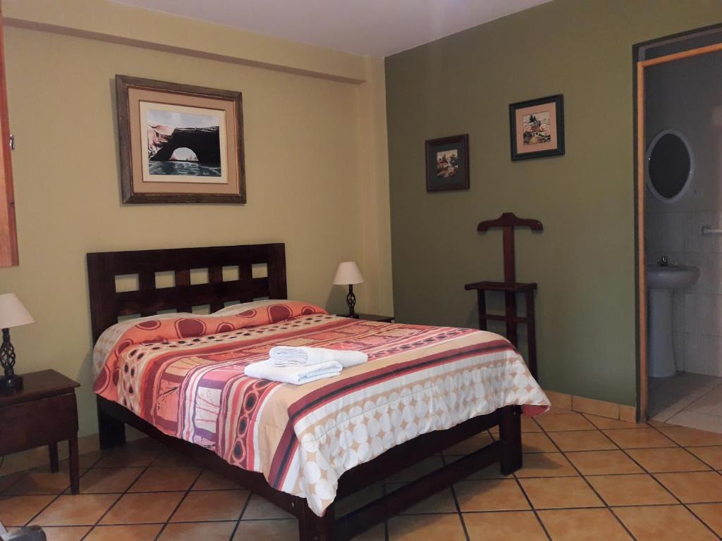 um quarto com uma cama e um lavatório em Hostal Tambo Colorado em Pisco