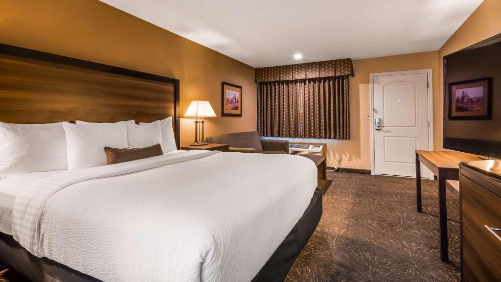 a hotel room with a large bed and a desk at Best Western John Day Inn in John Day