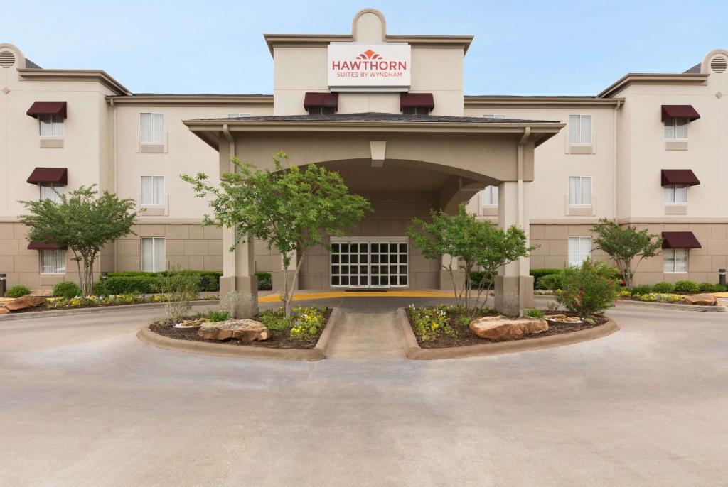 a front view of a hotel with a parking lot at Hawthorn Extended Stay by Wyndham College Station in College Station