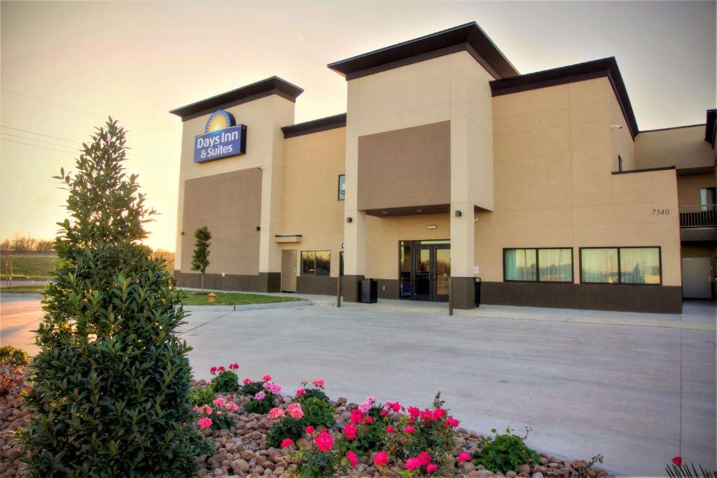 a hospital building with flowers in front of it at Days Inn & Suites by Wyndham Port Arthur in Port Arthur