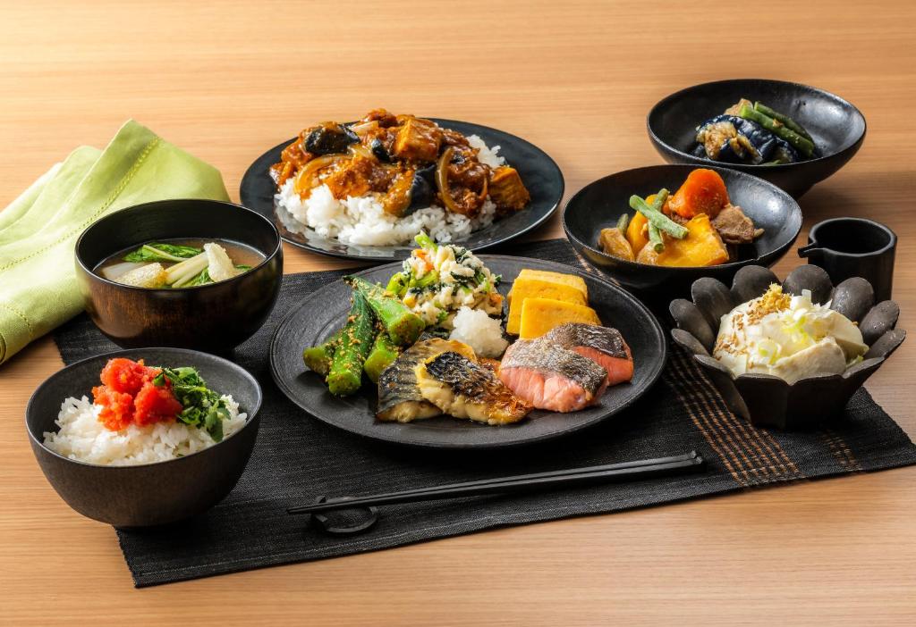 un groupe de plaques alimentaires sur une table dans l'établissement Candeo Hotels Osaka Kishibe, à Suita