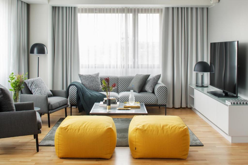 a living room with a couch and yellow ottoman at Original Sokos Hotel Presidentti Helsinki in Helsinki