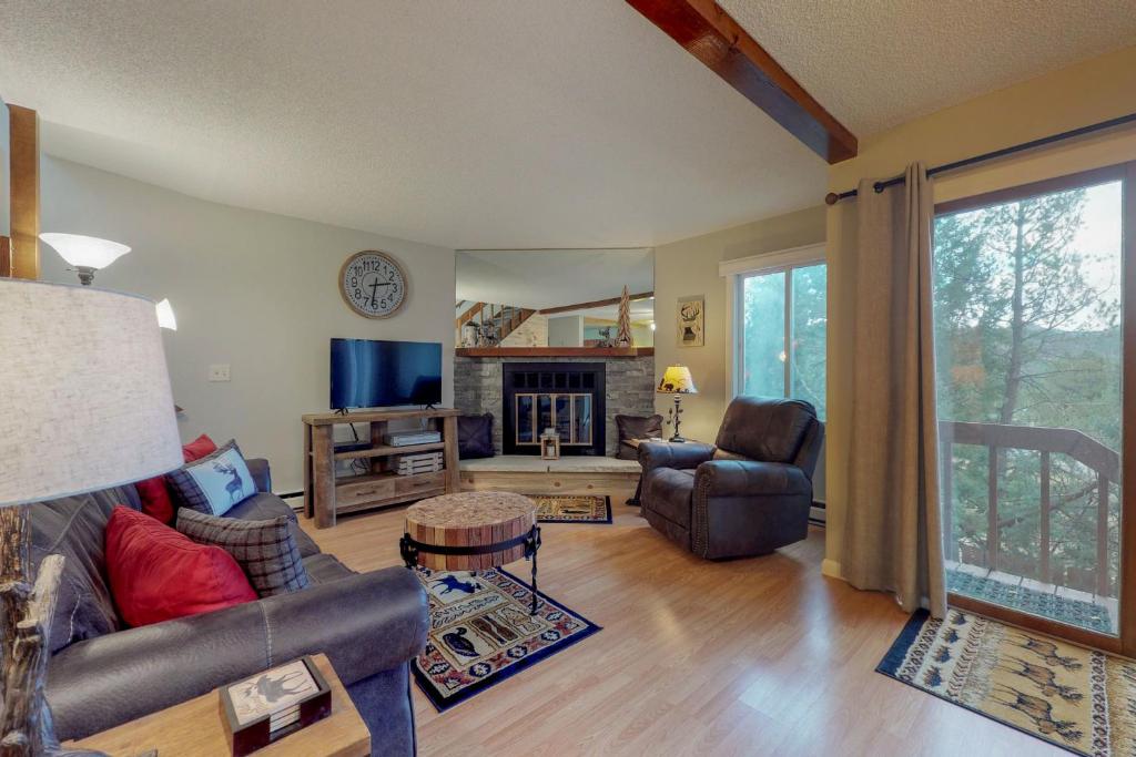 een woonkamer met een bank en stoelen en een tv bij Eagle View G2 in Estes Park