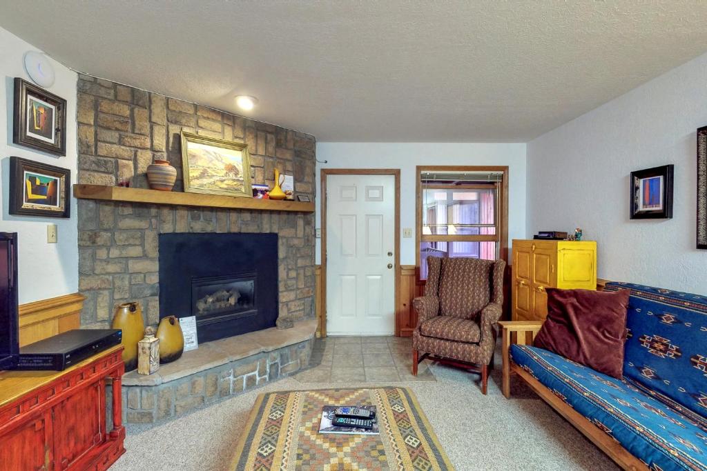 ein Wohnzimmer mit einem Kamin und einem Sofa in der Unterkunft Snowfire 208B in Angel Fire