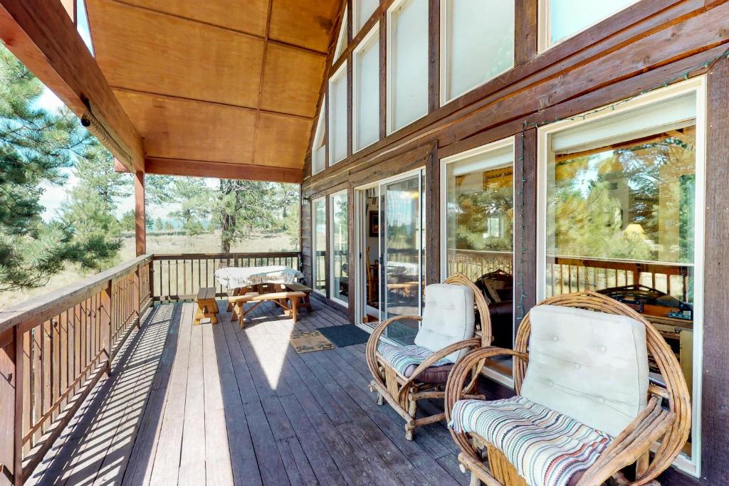 a porch with chairs and windows on a house at Painted Pony Cabin in Angel Fire