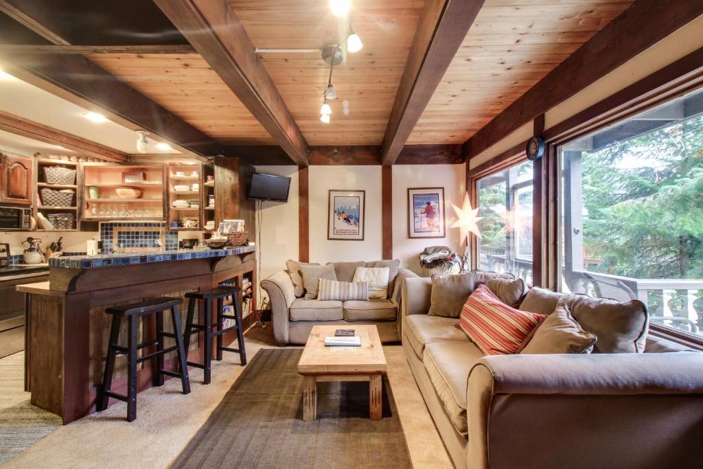 uma sala de estar com um sofá e um bar em Hyak Duplex Cabin em Snoqualmie Pass
