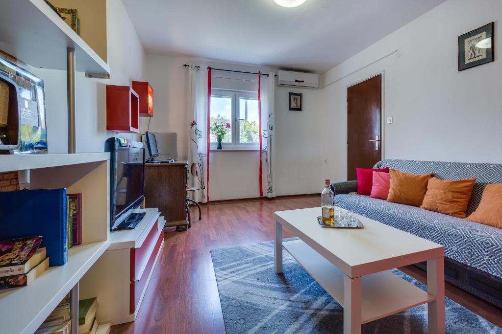 uma sala de estar com um sofá e uma mesa em Apartments Grancarić em Zadar