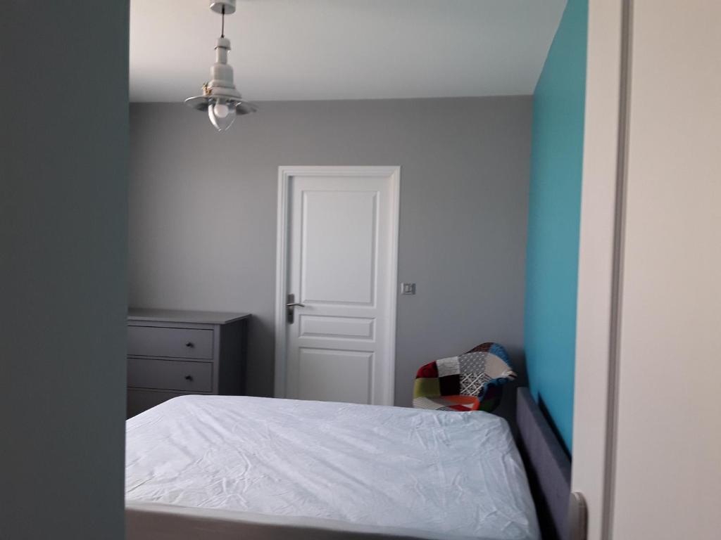 sypialnia z łóżkiem i niebiesko-białą ścianą w obiekcie Petite suite sympa Avoine w mieście Avoine