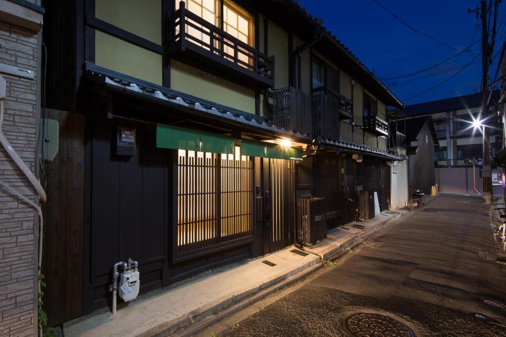 a building with a gate on a street at night at MACHIYA de HIGASHIYAMA in Kyoto
