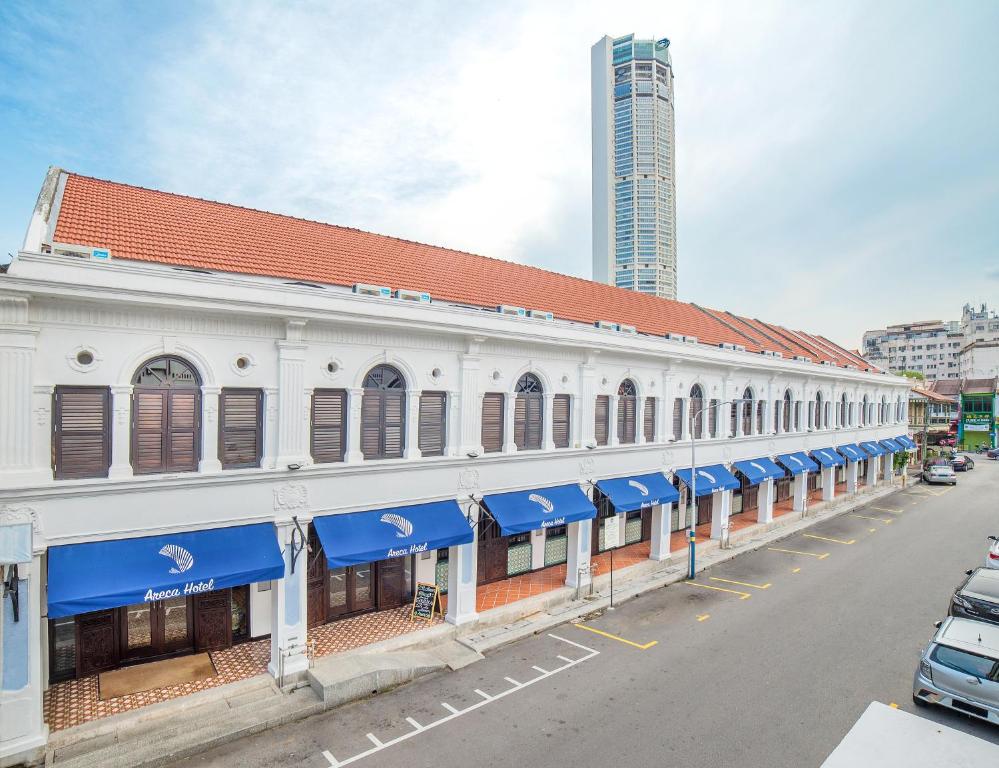 a building with blue awnings on the side of a street at Areca Hotel Penang in George Town