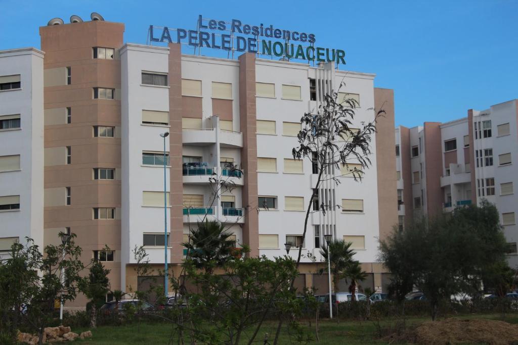 um edifício com um sinal em cima em Comme à la maison 1 em Nouaseur