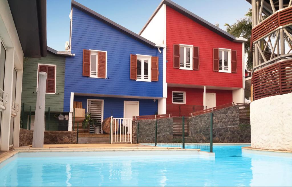 Deux maisons colorées avec une piscine en face dans l'établissement Stella Foresta, à Saint-Leu