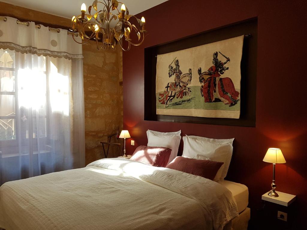 a bedroom with a large bed and a chandelier at Appartement Le Cardinal in Sarlat-la-Canéda