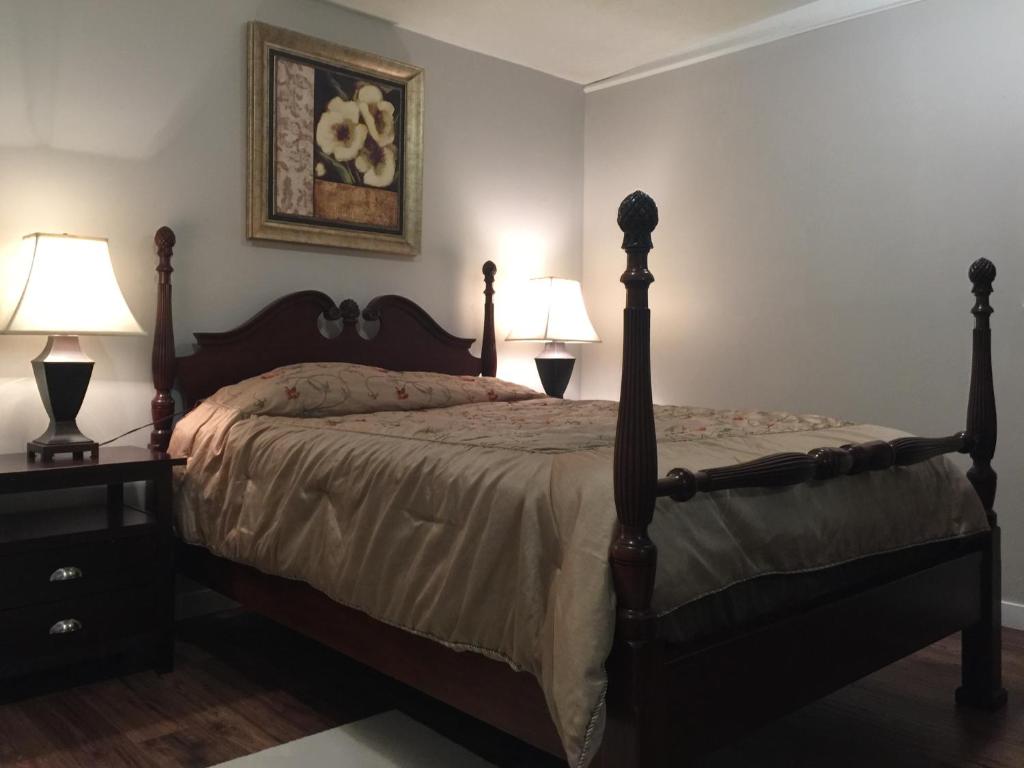 1 dormitorio con 1 cama con 2 lámparas y 1 foto en Chilliwack Accomodation, en Chilliwack