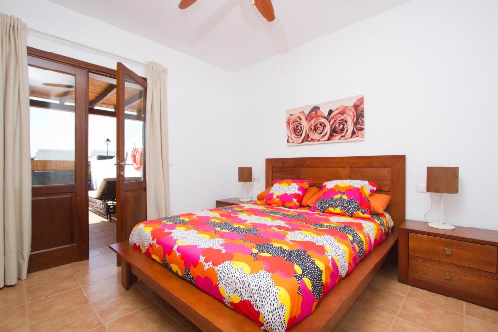 プラヤ・ブランカにあるVilla Andresのベッドルーム1室(カラフルな掛け布団付きのベッド1台付)