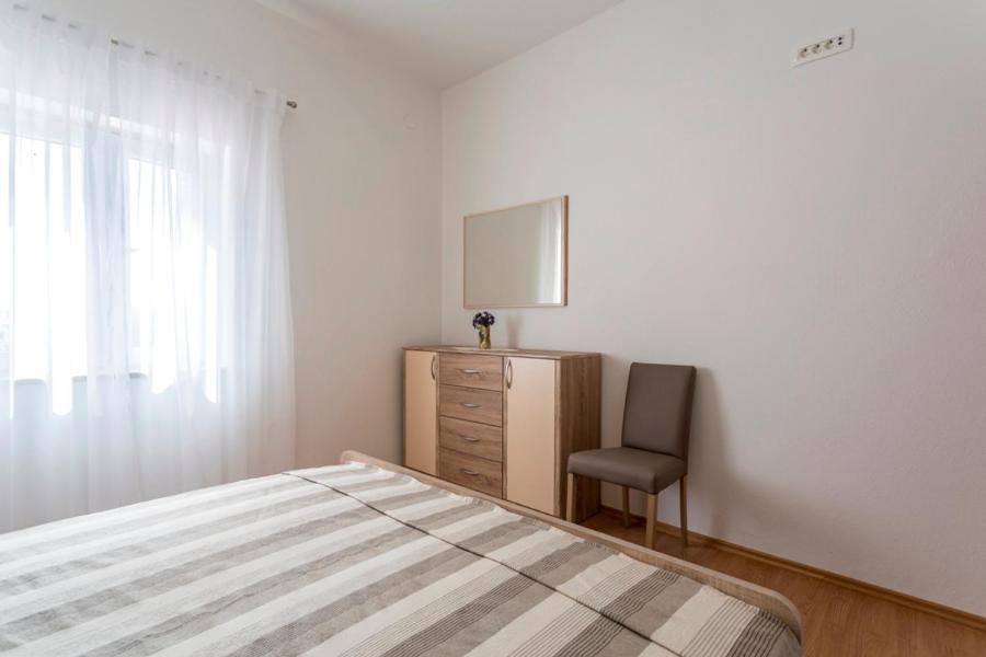 Postel nebo postele na pokoji v ubytování Apartmani Bezmalinović