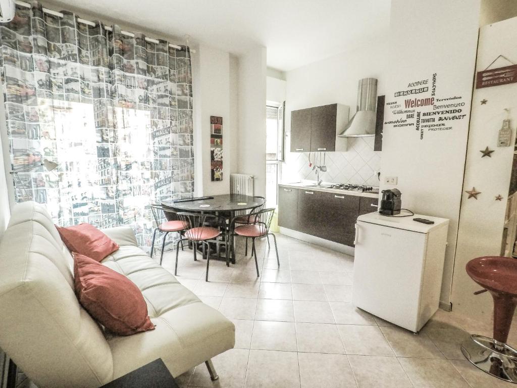ein Wohnzimmer mit einem weißen Sofa und einer Küche in der Unterkunft Residenza Riva Reno - BOLOGNA in Bologna