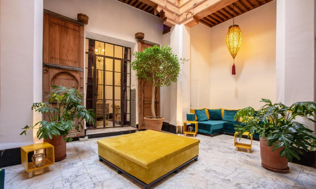 sala de estar con reposapiés amarillo y sofá en La Maison Maure, en Fez