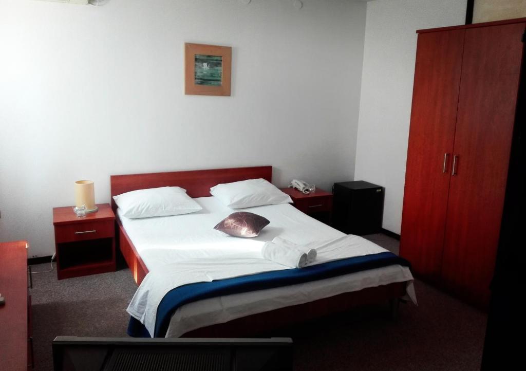 a bedroom with a bed and a red cabinet at Hotel Park in Višići