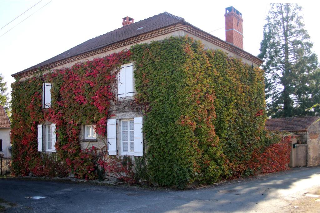 een huis bedekt met klimop bij Au Relais de Nèche. in Bègues