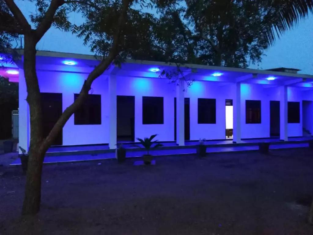 een gebouw met 's nachts blauwe lichten bij Quench Inn in Ampara