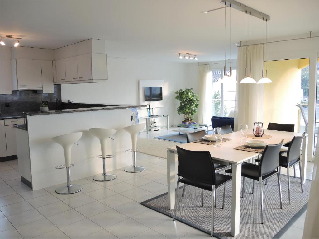 una cucina e una sala da pranzo con tavolo e sedie di Bicledro ad Ascona