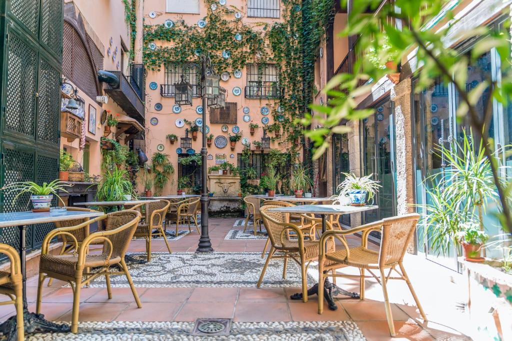 
a patio area with tables, chairs and umbrellas at Hotel Posada del Toro in Granada
