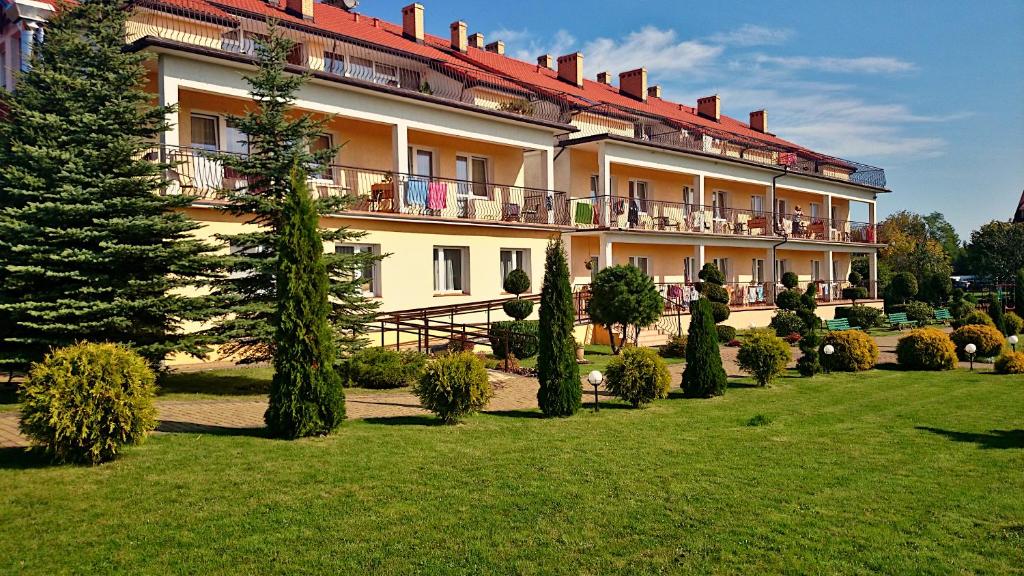 a large building with a garden in front of it at Bursztynowy Brzeg in Sarbinowo