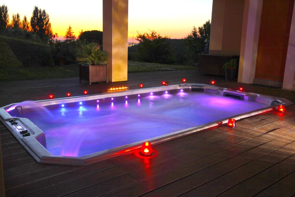 una piscina con luces en un patio trasero en Chambres d'hôtes - Villa CARPE DIEM TOLOSA, en Vieille-Toulouse