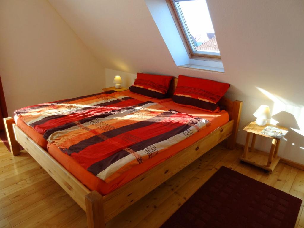 Un dormitorio con una cama con almohadas rojas y una ventana en Ferienwohnungen Hass - Haus 10 en Fehmarn