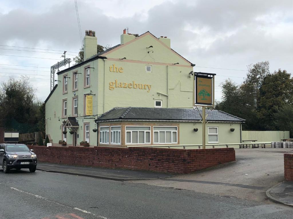 a building with a sign on the side of it at The Glazebury bar and restaurant with accommodation in Glazebury