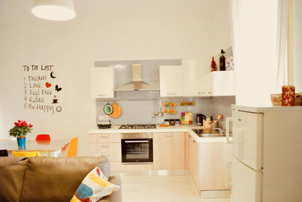 a kitchen with white cabinets and a refrigerator at Appartamento Annurca in Naples