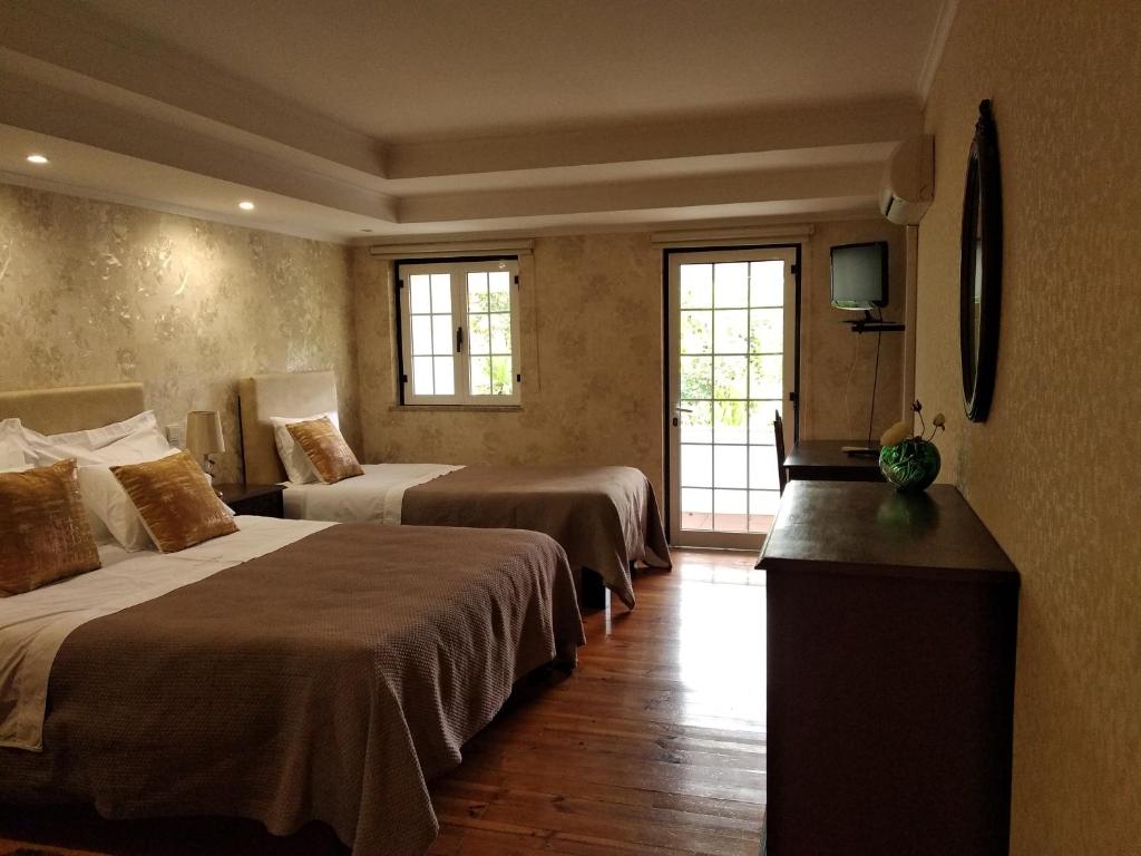 a hotel room with two beds and a television at Quinta da Telheira in Vila Real