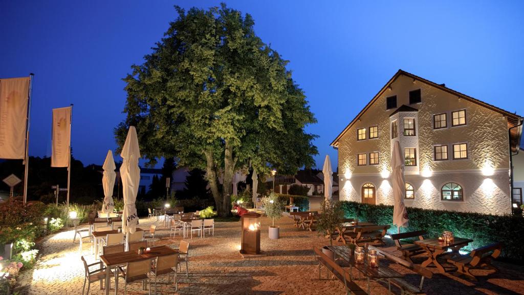 un patio con mesas y sillas y un edificio en ALTE LINDE Landhotel & Restaurant en Aalen