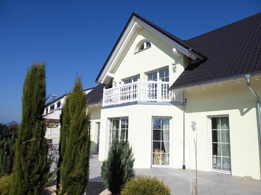 a white house with a black roof at Ferienwohnung Mia in Uhldingen-Mühlhofen