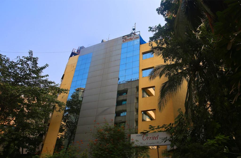 a tall yellow building with a sign on it at Hotel Orritel West in Mumbai