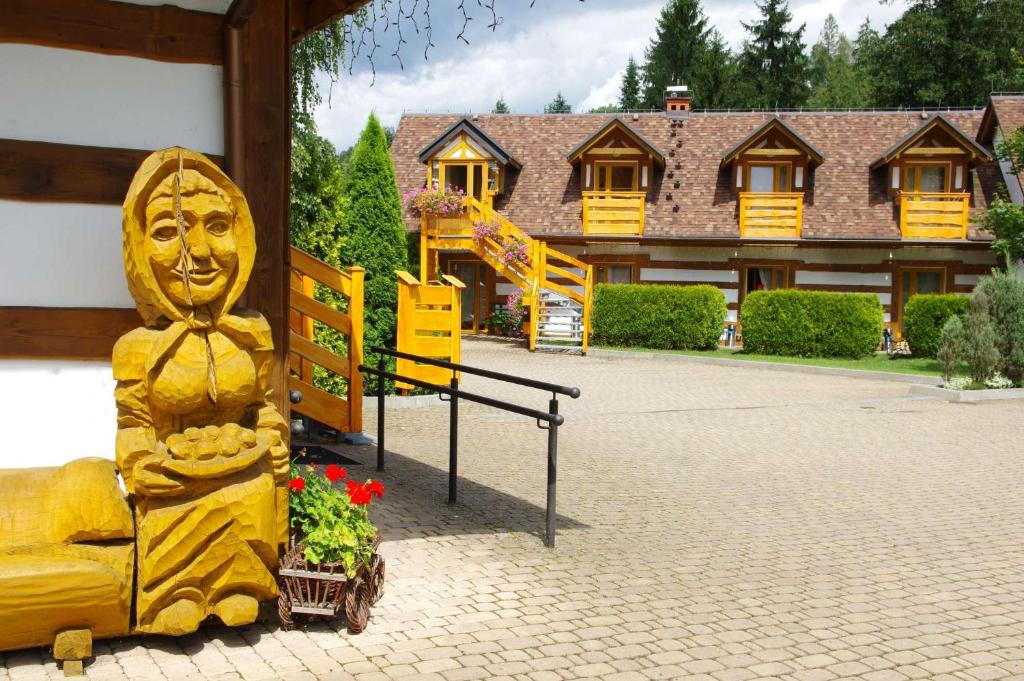 una statua gialla di un volto accanto a un edificio di Kamratowo a Wisła