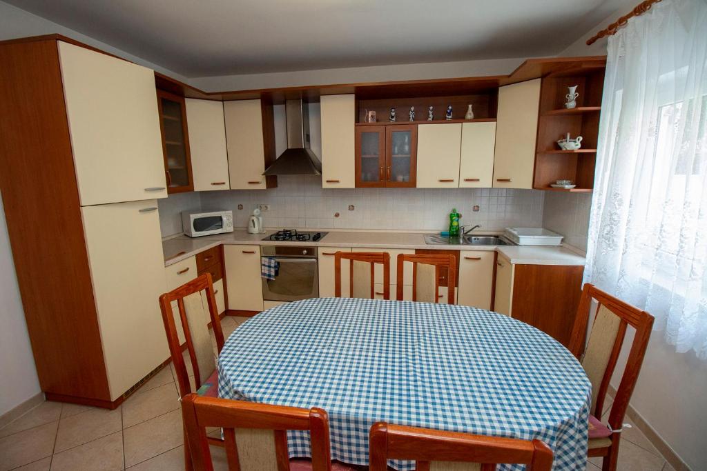 cocina con mesa, mesa y sillas en Apartmani Vrljičak, en Omiš