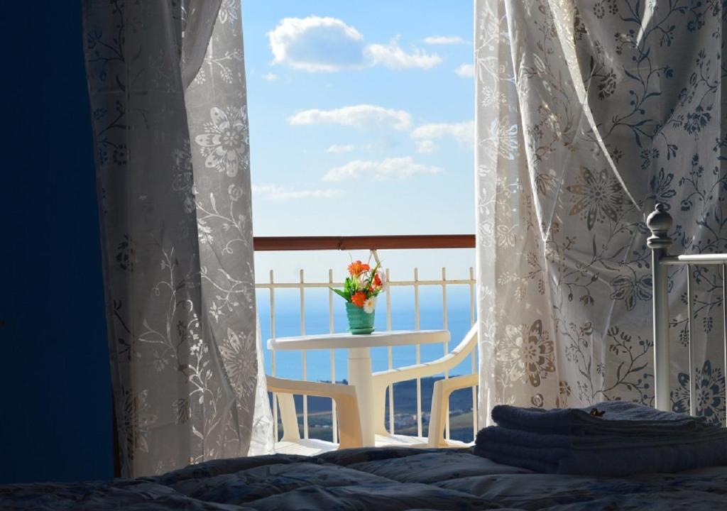 1 dormitorio con mesa y ventana con vistas al océano en B&B MiraValle Agrigento en Agrigento
